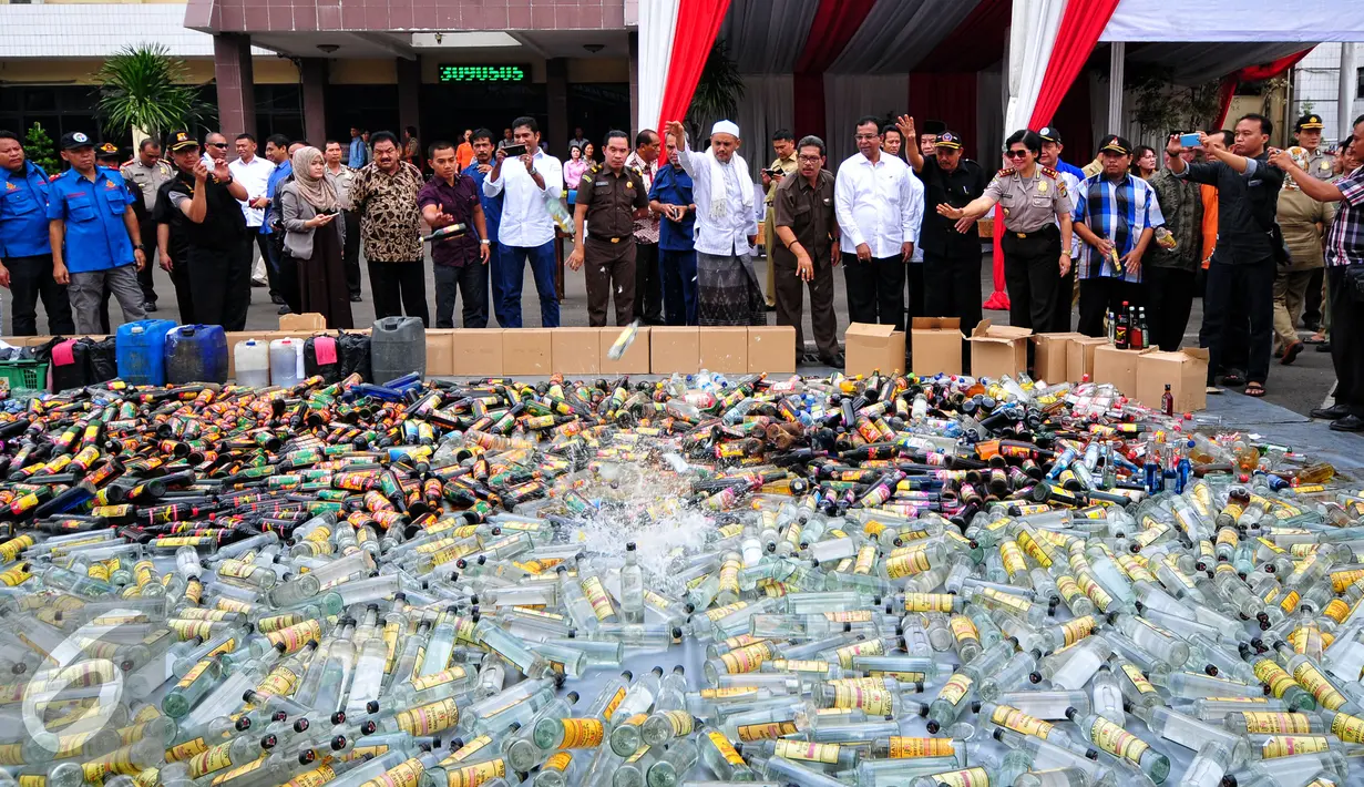 Petugas memusnakan ribuan botol miras hasil operasi penyakit masyarakat (pekat) 2015 di halaman Polres Jaksel, Rabu (10/6/2015). Pemusnahan 8.000 botol miras untuk menekan peredaran miras khususnya menjelang bulan Ramadan. (Liputan6.com/Yoppy Renato)