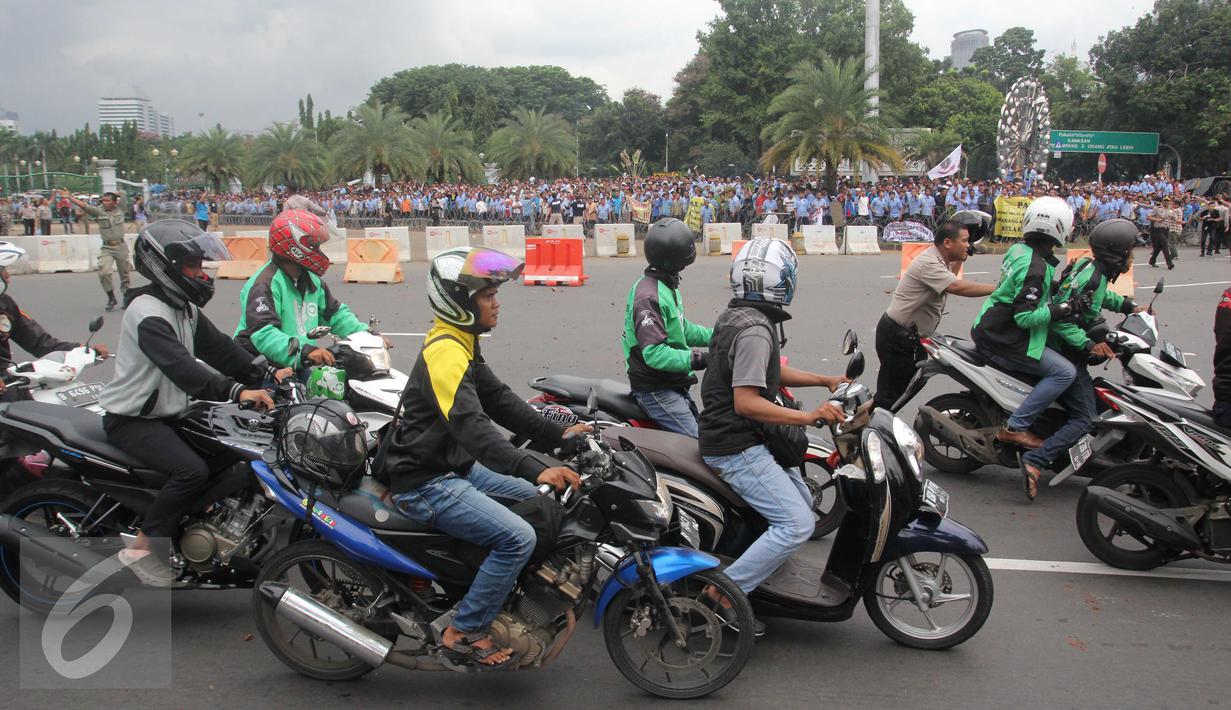 Pengemudi ojek online dilempari batu oleh sopir taksi yang melakukan unjuk rasa di depan Istana Negara, Jakarta, Selasa (22/3). Aksi itu pecah saat pengunjuk rasa mendapat ejekan dari pengemudi ojek online. (Liputan6.com/Gempur M Surya)