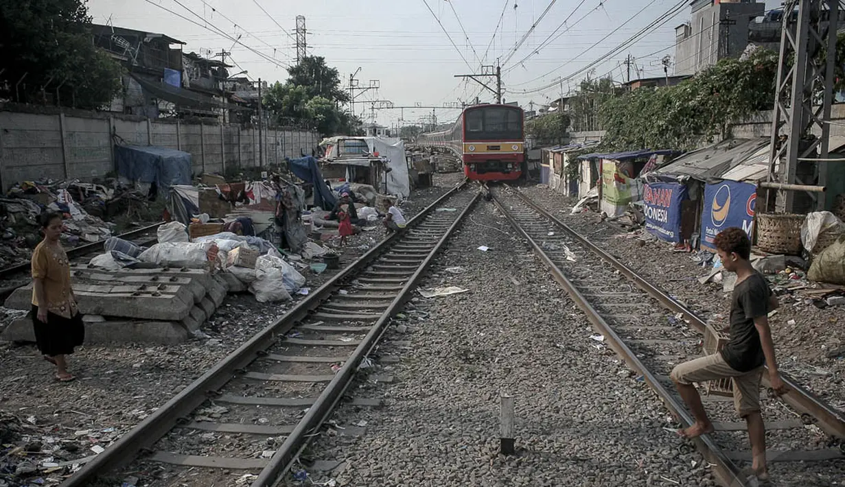 Selain mengganggu lalu lintas kereta, bangunan kumuh di bantaran rel kereta api ini pun membahayakan penghuni jika kereta melintasi kawasan tersebut, Jakarta, (26/9/14). (Liputan6.com/Faizal Fanani)