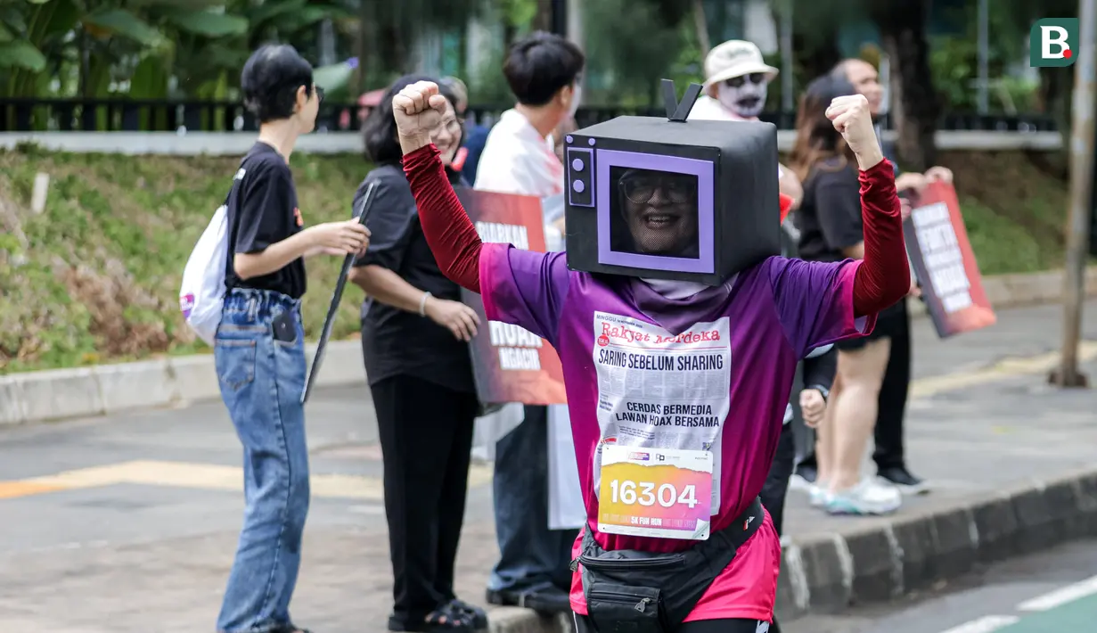 Seorang peserta lari menggunakan kostum berbentuk televisi dalam ajang Run for Journalism 2025 yang berlangsung di Unika Atma Jaya, Jakarta, Minggu (16/11/2025). (Bola.com/Bagaskara Lazuardi)