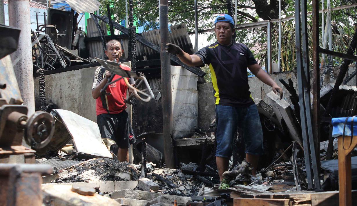 Aksi balas dendam massa terjadi dengan melakukan pembakaran tenda pedagang dan kendaraan. Tampak dalam foto, pemilik kios membersihkan puing-puing bangunan usai kebakaran yang melanda deretan kios di kawasan Kalibata, Jakarta Selatan, pada Jumat (12/12/2025). (merdeka.com/magang/Rendi Saputra)