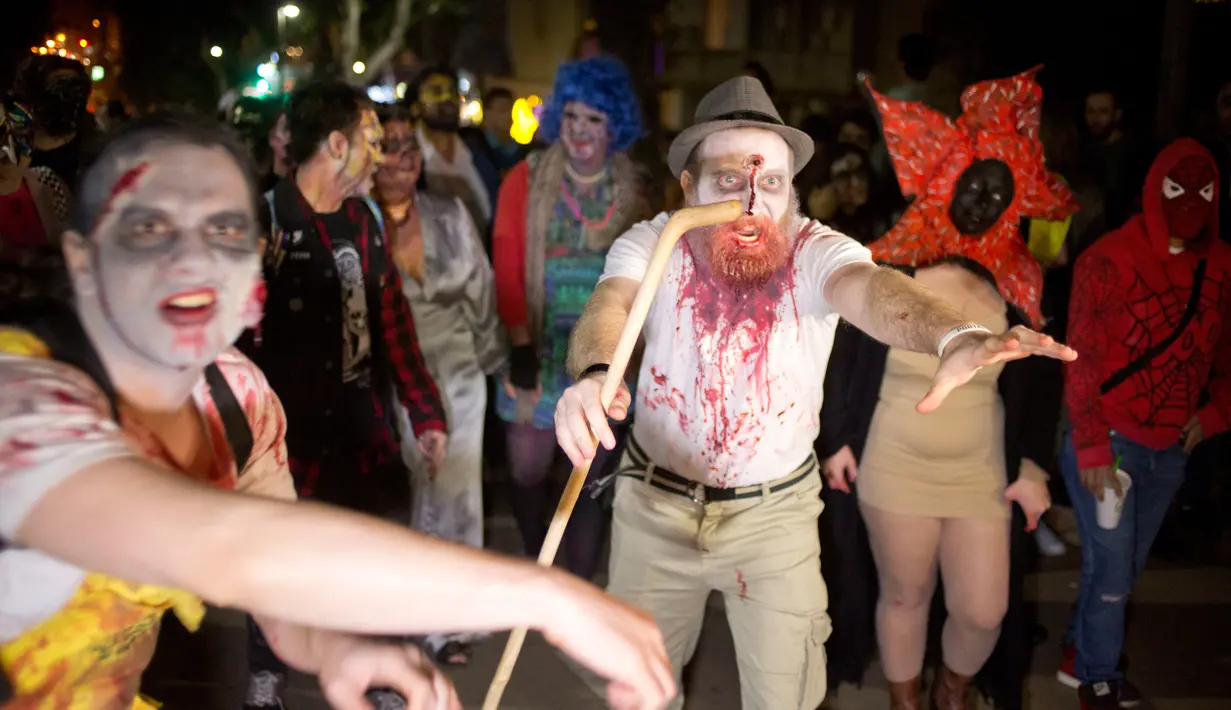 Sejumlah orang turun ke jalan dengan mengenakan kostum zombie saat mengikuti Zombie Walk dalam Festival Purim di Tel Aviv, Israel (3/3). Liburan Purim ini dirayakan dengan parade dan pesta kostum. (AP Photo/Ariel Schalit)
