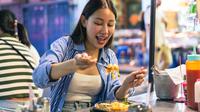 Seorang wanita menikmati makanan pedas. (twinsterphoto/depositphotos.com)