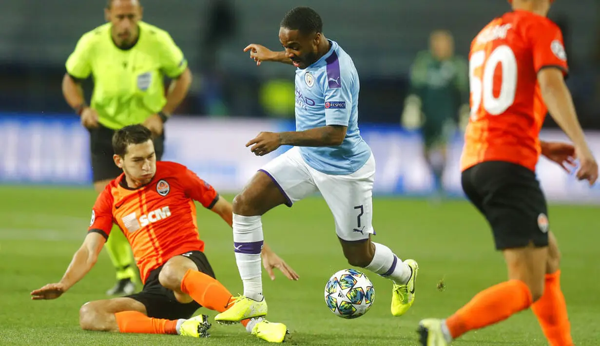Striker Manchester City, Raheem Sterling, berusaha melewati pemain FC Shakhtar Donetsk pada laga Liga Champions di Stadion Metalist, Rabu (18/9/2019). Manchester City menang 3-0 atas FC Shakhtar Donetsk. (AP/Efrem Lukatsky)