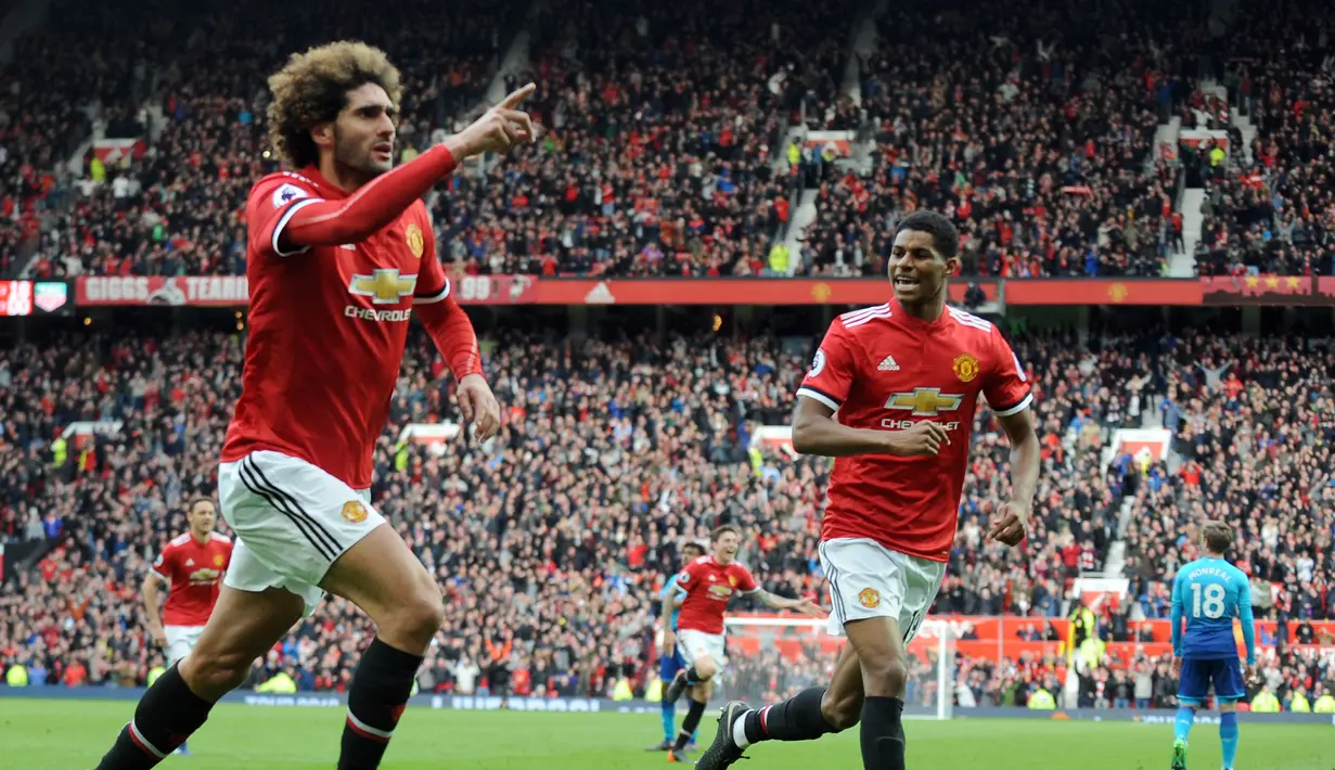 Pemain Manchester United Marouane Fellaini merayakan golnya saat melawan Arsenal dalam pertandingan Liga Inggris di stadion Old Trafford di Manchester (29/4). Gol kemenangan ini berhasil diciptakan oleh Fellaini pada menit ke-90. (AFP/Paul Ellis)