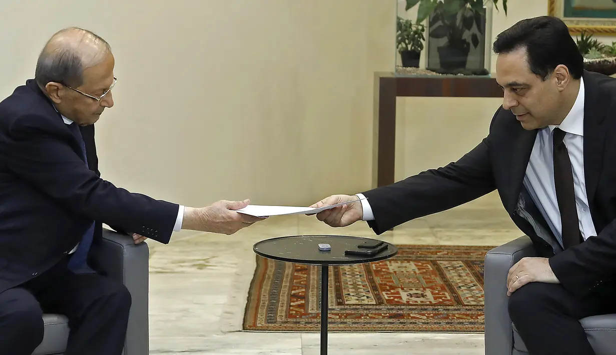 PM Lebanon, Hassan Diab (kanan) mengajukan pengunduran dirinya kepada Presiden Michel Aoun di istana presiden di Baabda, ibu kota Beirut pada 10 Agustus 2020. Pengunduran diri Diab dilakukan di tengah kemarahan rakyat atas ledakan besar di Beirut pada 4 Agustus lalu. (HO/DALATI AND NOHRA/AFP)