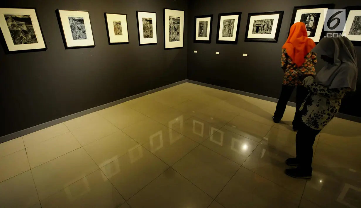 Pengunjung menikmati deretan foto Melampaui Fotografi karya Suherry Arno di Galeri Nasional, Jakarta, Selasa (24/10). Pameran foto tunggal karya Suherry Arno ini berlangsung hingga 5 November 2017. (Liputan6.com/Helmi Fithriansyah)