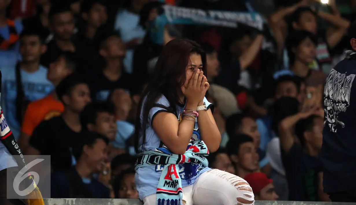 Suporter Persela menutup wajahnya saat menyaksikan kekalahan timnya melawan Persija padalanjutan Torabika Soccer Championship presented by IM3 Ooredoo di Stadion GBK Jakarta, Jumat (13/5). Persela kalah 1-2 dari Persija. (Liputan6.com/Helmi Fithriansyah)