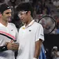 Petenis Swiss, Roger Federer (kiri), bersalaman dengan Hyeon Chung setelah laga semifinal Australia Terbuka 2018, di Melbourne, Jumat (26/1/2018). (AP Photo/Andy Brownbill)