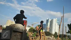 Seorang bocah bermain layang-layang di area Tempat Pemakaman Umum (TPU) Menteng Atas, Jakarta, Rabu (8/6). Minimnya tempat bermain membuat anak-anak bermain di Tempat Pemakaman Umum (TPU)  . (Liputan6.com/Gempur M Surya)