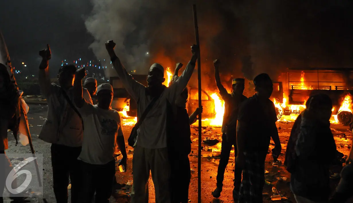 Sejumlah pendemo berteriak di dekat mobil yang terbakar di kawasan Monas, Jakarta, Jumat (4/11). Aksi Damai 4 November ini berakhir ricuh dengan terjadi bentrok antara pendemo versus polisi. (Liputan6.com/Angga Yuniar)