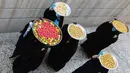 Sejumlah perempuan membawa kue untuk perayaan Idul Fitri yang akan datang di Basra, Irak, Jumat (22/5/2020). Idul Fitri menandai berakhirnya bulan suci Ramadan. (AP Photo/Nabil al-Jurani)