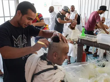 Jemaah haji mencukur rambut kepala atau tahalul usai melaksanakan lempar jumrah, Mina, Arab Saudi, Minggu (11/8/2019). Tahalul termasuk ke dalam serangkaian ibadah haji. (FETHI BELAID/AFP)