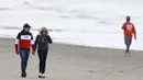 <p>Presiden Prancis Emmanuel Macron dan istrinya Brigitte Macron berjalan di sepanjang pantai di Le Touquet, menjelang putaran kedua pemilihan presiden Prancis, Sabtu (23/4/2022). Emmanuel Macron akan menghadapi Marine Le Pen dalam putaran kedua pemilihan presiden (pilpres) pada 24 April 2022. (Ludovic MARIN / AFP)</p>
