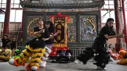 Lin Xinmeng merupakan salah satu penari barongsai wanita yang berlatih dan tergabung dalam kelompok di sebuah kuil leluhur di Shantou, provinsi Guangdong, Tiongkok selatan. (Jade GAO/AFP)