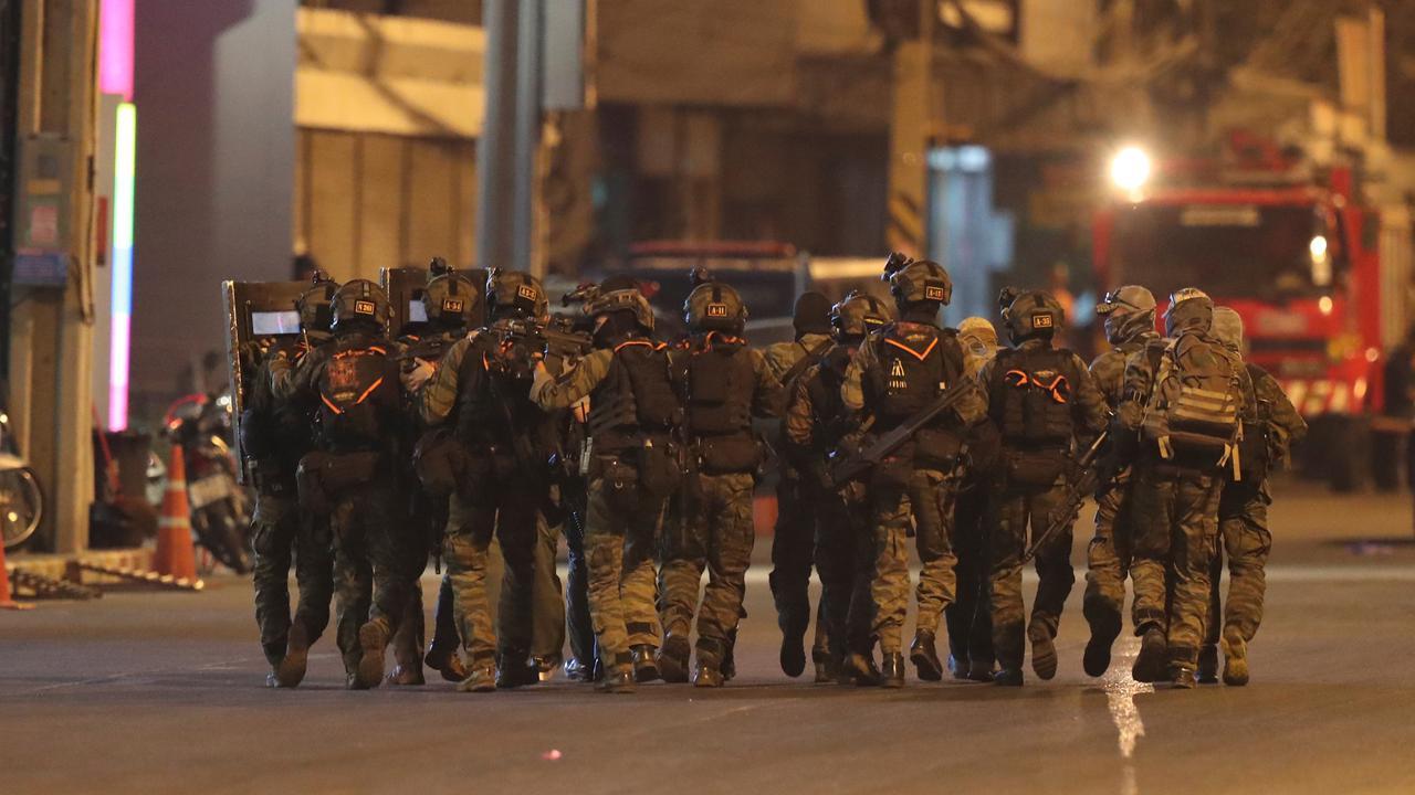 Sejumlah tentara komando bersenjata berjalan di luar mal Terminal 21 Korat saat terjadi penembakan di Nakhon Ratchasima, Thailand, Minggu (9/2/2020).