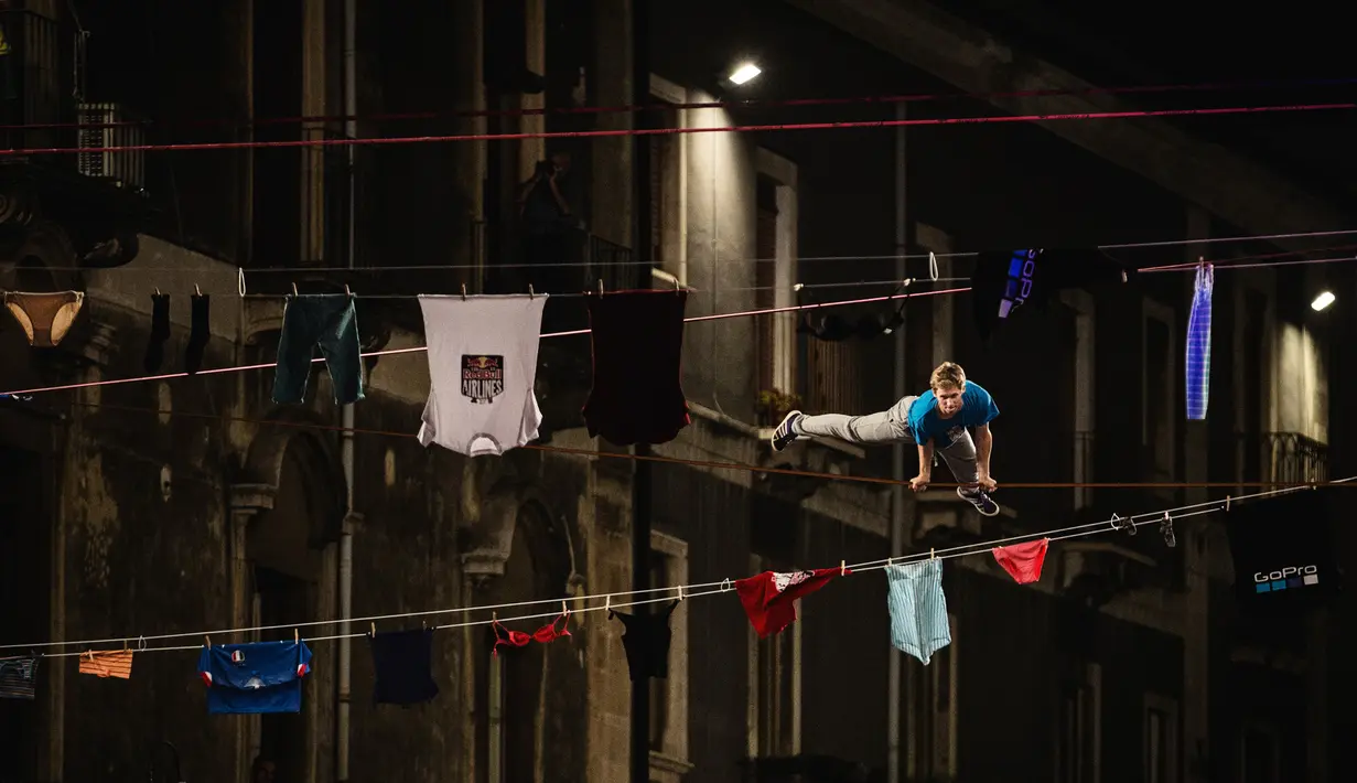 Seorang peserta beraksi di kompetisi slackline Red Bull Airlines di Catania, Italia, Sabtu (8/10). Red Bull Airlines adalah kompetisi slackline yang digelar di ketinggian 7 meter di atas tanah.(REUTERS)