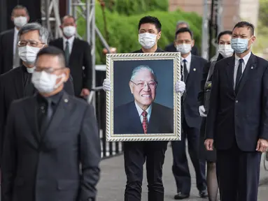 James Zhao, cucu menantu mantan Presiden Taiwan Lee Teng-hui membawa potret Lee saat prosesi pemakaman di Pemakaman Militer Wuzhi Mountain di New Taipei City, Rabu (7/10/2020). Lee, yang dianggap sebagai "bapak demokrasi Taiwan", meninggal Juli lalu di usia 97 tahun. (Military News Agency via AP)