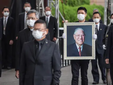 James Zhao, cucu menantu mantan Presiden Taiwan Lee Teng-hui membawa potret Lee saat prosesi pemakaman di Pemakaman Militer Wuzhi Mountain di New Taipei City, Rabu (7/10/2020). Lee, yang dianggap sebagai "bapak demokrasi Taiwan", meninggal Juli lalu di usia 97 tahun. (Military News Agency via AP)