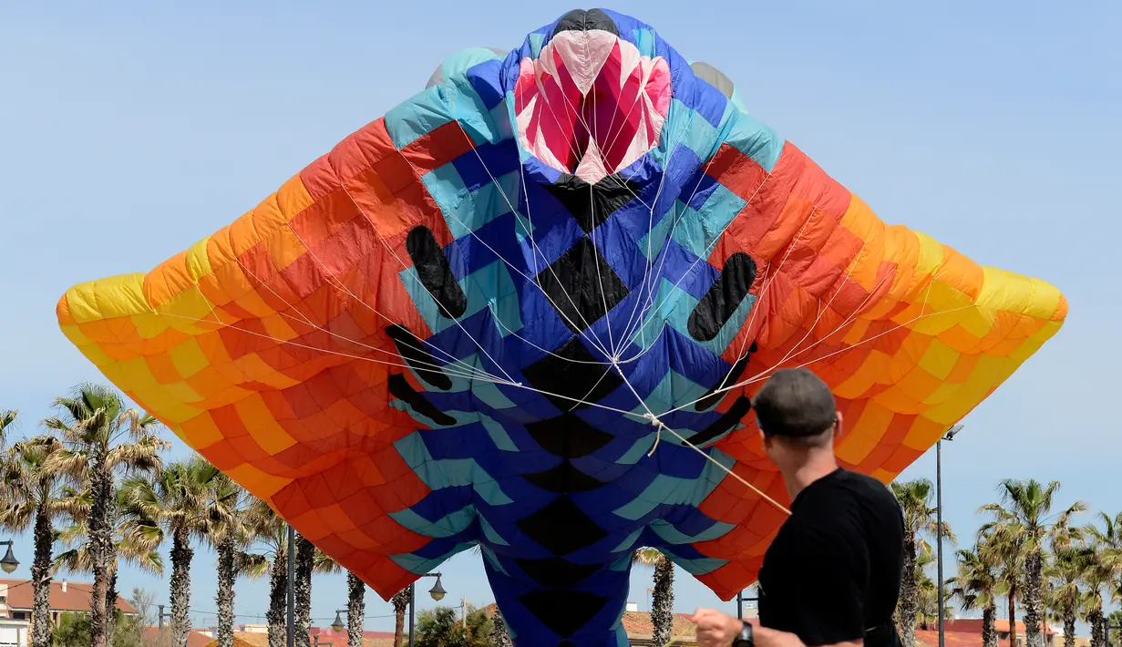 Seorang peserta berusaha menerbangkan layang-layang saat mengikuti Festival Internacional del Viento (Festival Angin Internasional) di pantai Malvarrosa, di Valencia, Spanyol (23/4). (AFP/Jose Jordan)