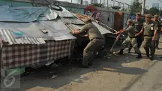 Petugas Satpol PP menertibkan sekitar 300 gubuk liar disepanjang Jalan Inspeksi Kanal Banjir Barat (KBB), Rabu (13/7). Penertiban dilakukan lantaran gubuk liar tersebut berdiri di bahu jalan dan mengganggu ketertiban umum. (Liputan6.com/Gempur M Surya)