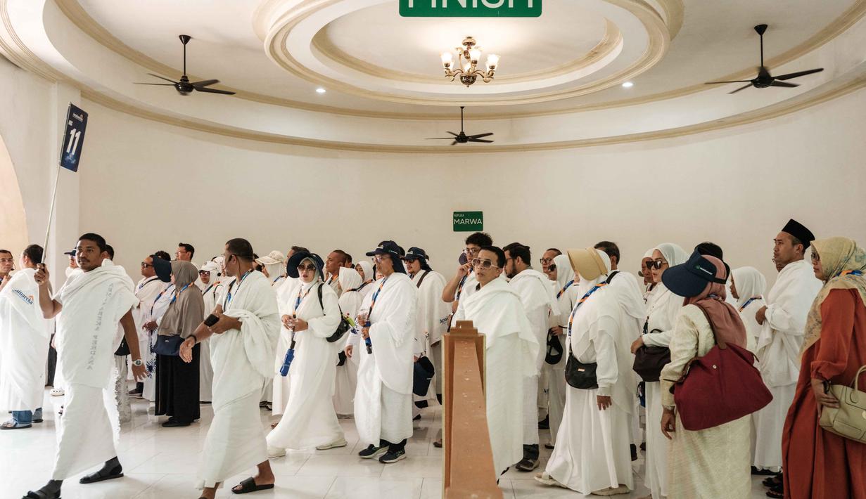 Sebagai informasi, kuota haji Indonesia untuk tahun 2026 ditetapkan sebanyak 221.000 jemaah, dengan rata-rata waktu tunggu nasional sekitar 26 tahun. Tampak dalam foto, calon jamaah haji Indonesia berlatih ritual haji menggunakan replika tempat-tempat suci di Pusat Pelatihan Manasik Al Mahmudah (AMTC), sebuah fasilitas pelatihan haji yang menampilkan replika tempat-tempat ziarah utama, di Tangerang Selatan pada 5 April 2026. (YASUYOSHI CHIBA/AFP)