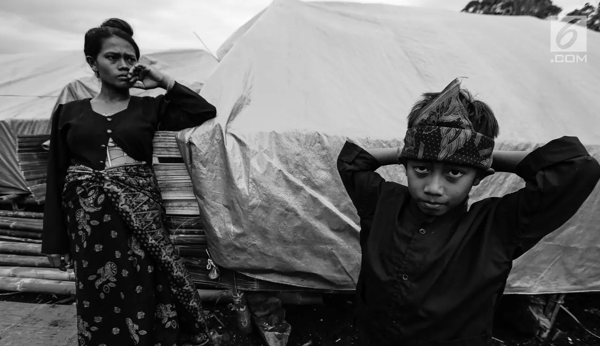 Seorang ibu dan anak Suku Baduy Luar di depan rumah yang dibangun dengan tenda di lokasi bekas kebakaran Kampung Cisaban II, Desa Kanekes, Banten, Kamis (1/6). Kebakaran pekan lalu itu menghanguskan 83 rumah Suku Baduy Luar. (Liputan6.com/Fery Pradolo)