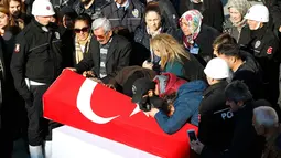 Suasana duka saat keluarga dari anggota Polisi yang tewas dalam ledakan bom melepas kepergian jenazah di Istanbul, Turki (11/12). Presiden Tayyib Erdogan mengatakan ledakan tersebut sebagai serangan teroris terhadap polisi dan warga. (Reuters/Murad Sezer)