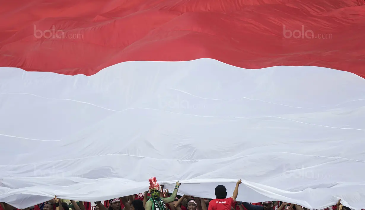 Suporter membentangkan merah putih raksasa saat laga Timnas Indonesia melawan Timor Leste pada laga SEA Games di Stadion MPS, Selangor, Minggu (20/8/2017). Indonesia menang 1-0 atas Timor Leste. (Bola.com/Vitalis Yogi Trisna)