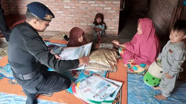 Personel Brimob Polda Riau saat berkunjung ke rumah guru honorer yang kehidupannya terbatas secara ekonomi.