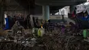 Para tunawisma beristirahat di sepetak tanah di bawah jembatan penyeberangan di sebelah rel kereta api pada pagi yang dingin di New Delhi, 30 Desember 2022. Musim dingin yang keras disalahkan karena membunuh puluhan tunawisma dan membuat puluhan ribu lainnya menggigil di jalanan. (AP Photo/Altaf Qadri)