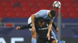 Pemain Manchester City, Ruben Dias, berebut bola dengan pemain Borussia Moenchengladbach, Alassane Plea, pada laga Liga Champions di Puskas Arena, Kamis (25/02/2021). City menang dengan skor 2-0. (AP/Laszlo Balogh)