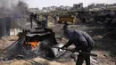 Seorang pria Palestina bekerja di pabrik darurat yang mengekstraksi Bahan Bakar Minyak (BBM) dari plastik daur ulang di Jabalia di Jalur Gaza utara pada 6 April 2025. (BASHAR TALEB/AFP)