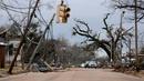 Mobil melewati pepohonan dan kabel listrik yang tumbang setelah tornado di Chestnut Blvd, Selma, Alabama, Amerika Serikat, 13 Januari 2023. Badai menyebabkan pemadaman listrik yang berdampak terhadap ribuan orang di empat negara bagian. (AP Photo/Stew Milne)