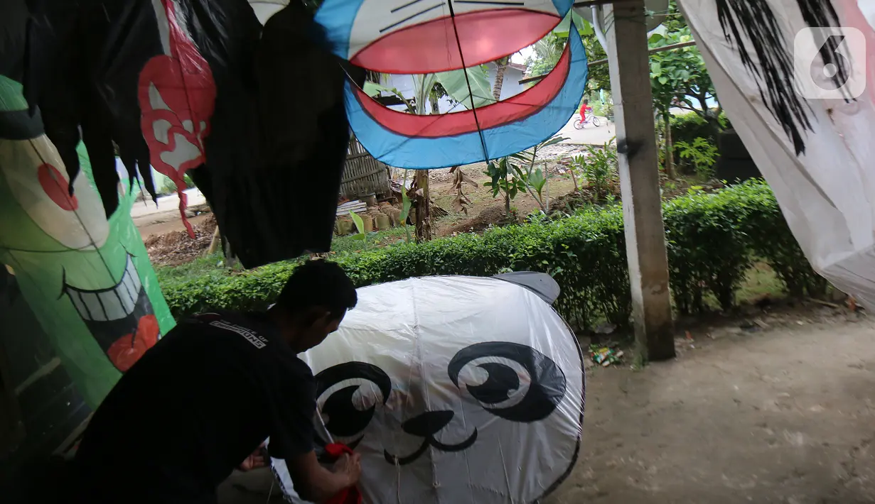 Perajin menyelesaikan pembuatan layang-layang Koang di Bedahan, Depok, Jawa Barat, Senin (20/7/2020). Kerajinan layangan berbahan rangka bambu, plastik, dan kain ramai diburu pada musim kemarau. (Liputan6.com/Fery Pradolo)