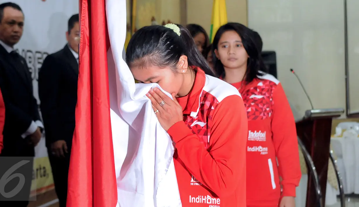 Kapten tim Uber Indonesia, Greysia Polii mencium bendera Merah Putih saat upacara pelepasan di Pelatnas PBSI, Jakarta, Senin (9/5/2016). Piala Thomas dan Uber akan dihelat di Kunshan, Tiongkok, 15-22 Mei mendatang. (Liputan6.com/Helmi Fithriansyah)