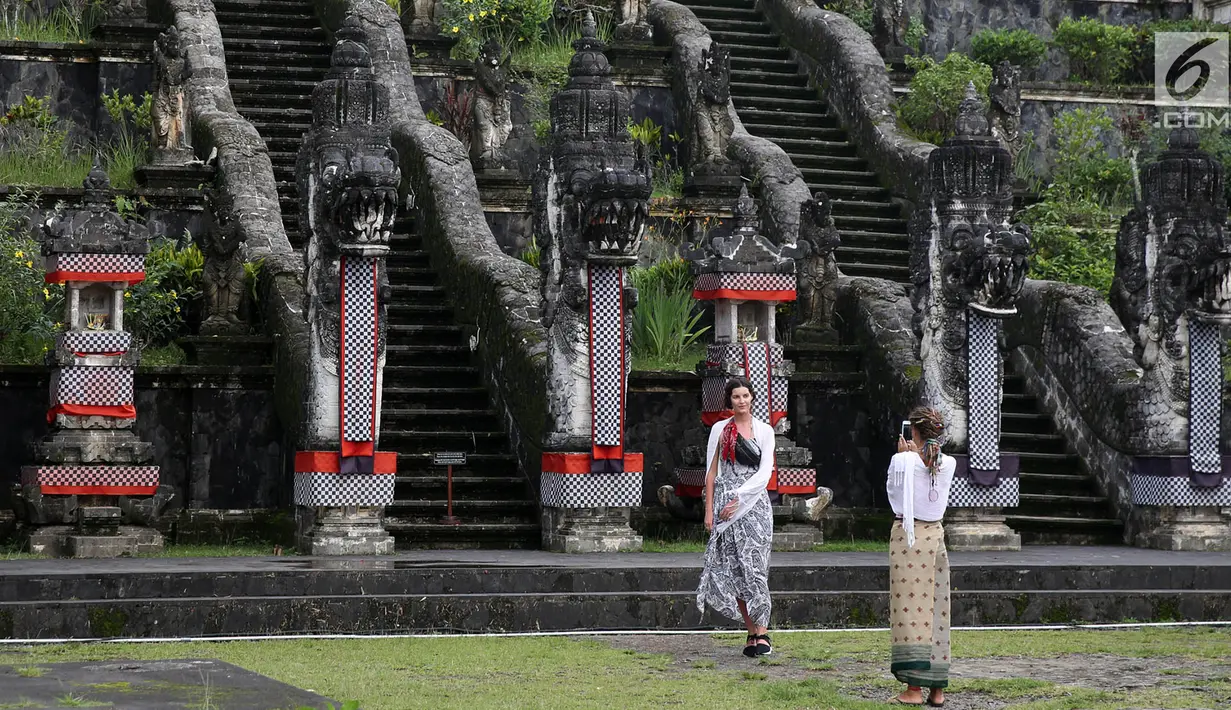 Wisatawan berfoto di sekitar Pelataran Agung Pura Lempuyang, Karangasem, Bali, Kamis (7/12). Erupsi Gunung Agung menyebabkan sejumlah destinasi wisata di kawasan Bali Timur mengalami penurunan jumlah wisatawan. (Liputan6.com/Immanuel Antonius)