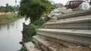 Tiang pancang dan saluran gorong-gorong menghiasi bantaran Sungai Ciliwung di kawasan Rawajati, Jakarta, Rabu (30/10/2019). Tiang-tiang pancang itu merupakan sisa proyek normalisasi Sungai Ciliwung dan telah berada di bantaran tersebut selama beberapa tahun terakhir. (Liputan6.com/Immanuel Antonius)
