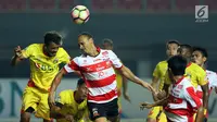 Gelandang Bhayangkara FC, Alfin Tuasalamony (kiri) berebut bola dengan pemain Madura United, Peter Odemwingie pada lanjutan Liga 1 Indonesia di Stadion Patriot Chandrabhaga, Bekasi, Kamis (13/7). Bhayangkara FC unggul 2-1 (Liputan6.com/Helmi Fithriansyah)