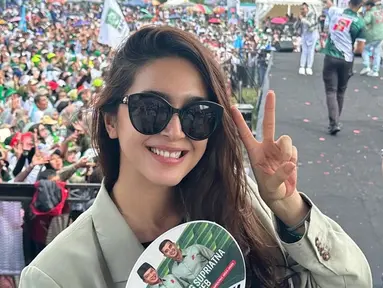 Tampil pakai blazer warna hijau, Nabila Syakieb tampil stylish. Lantaran digelar di lapangan, artis berusia 39 tahun ini memakai kacamata hitam untuk menghindari silaunya cahaya matahari. Nomor urut Dadang Supriatna-Ali Syakieb adalah nomor dua, Nabila Syakieb berpose dua jari sembari memegang kipas tangan dengan gambar Dadang Supriatna dan Ali Syakieb. (Liputan6.com/IG/@nsyakieb85)
