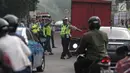 Petugas polisi lalu lintas memberhentikan kendaraan saat pemberlakuan sistem ganjil genap di pintu masuk Gardu Tol Cibubur 2, Jakarta, Senin (16/4). Kebijakan ini diterapkan untuk mengurai kemacetan di ruas Tol Jagorawi. (Liputan6.com/Faizal Fanani)