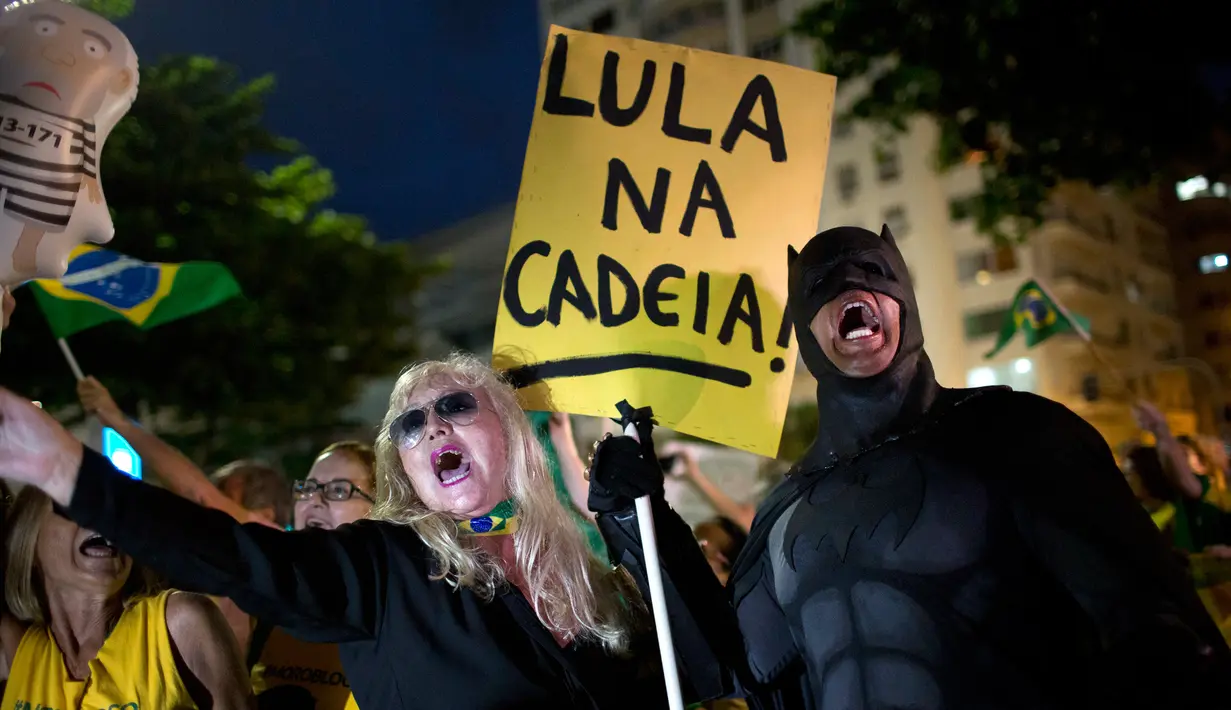 Seorang demonstran mengenakan kostum Batman saat mengikuti aksi protes di Rio de Janeiro, Brasil (3/4). Luiz Inacio Lula da Silva dijatuhi hukuman penjara hampir 10 tahun karena terbukti melakukan korupsi dan menerima suap. (AP / Silvia Izquierdo)