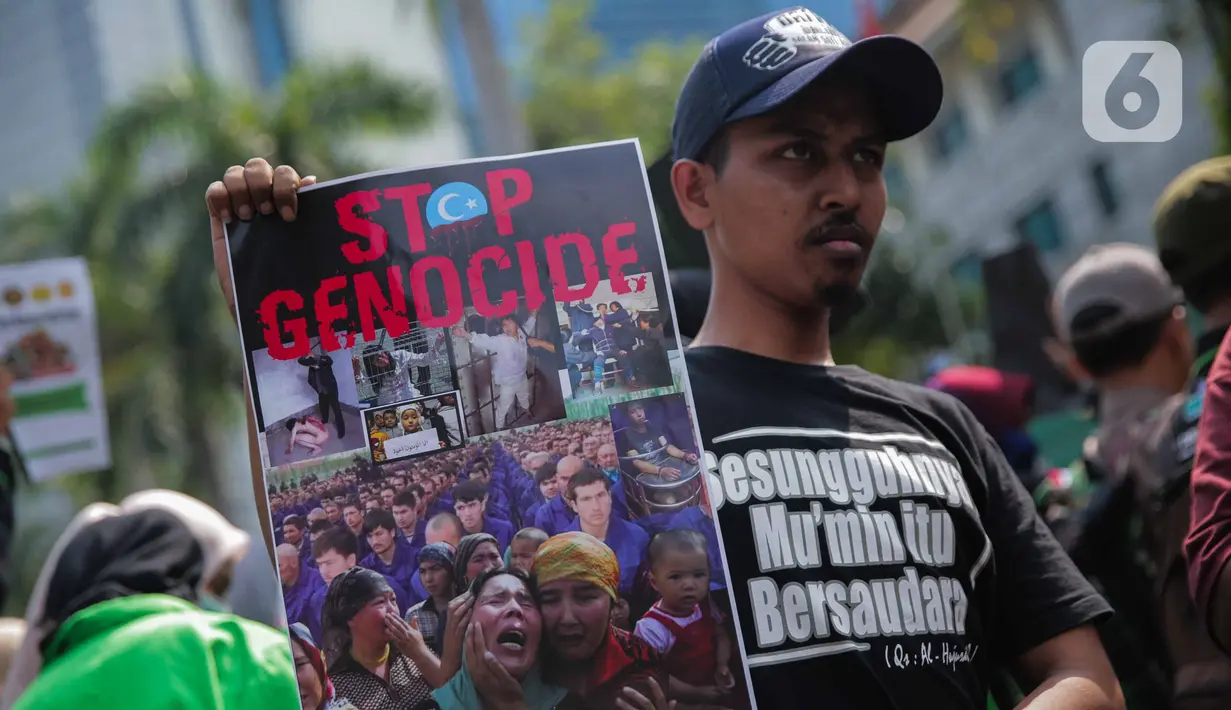 Massa membawa poster bertuliskan 'Stop Genocide' saat menggelar aksi Solidaritas untuk Muslim Uighur di depan Kedutaan Besar China di Jakarta, Jumat (20/12/2019). Mereka mengecam dan mengutuk keras penindasan terhadap muslim Uighur di China. (Liputan6.com/Faizal Fanani)