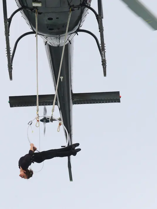 Erendira Wallenda meliuk-liukan tubuhnya di sebuah lingkaran yang dikaitkan pada helikopter yang terbang di atas Air Terjun Niagara, New York, Kamis (15/6). Helikopter itu terbang setinggi 91 meter di atas permukaan aliran air. (AP Photo/Bill Wippert)