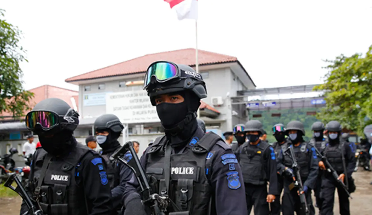 Aparat kepolisian dari satuan Brimob berjaga selama proses pemindahan tahanan di Nusakambangan, Cilacap, Jawa Tengah (4/3/2015). Dua terpidana mati penyelundup narkoba asal Australia sedang dipindahkan untuk menjalani eksekusi.  (Reuters/Darren Whiteside)