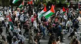 Para pengunjuk rasa memegang plakat dan mengibarkan bendera Palestina saat mereka mengambil bagian dalam “Pawai Nasional untuk Gaza”, di pusat kota London, pada 8 Juni 2024. (JUSTIN TALLIS/AFP)