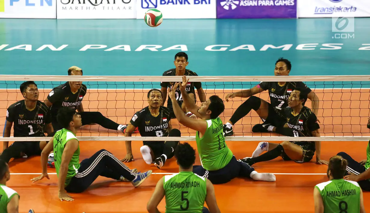 Tim voli duduk putra Indonesia bersiap menghadang smash pemain Iraq saat berhadapan pada pertandingan Asian Para Games di GBK, Jakarta, Senin (8/10). Indonesia kalah dari Iraq dengan skor 25-11, 25-10, dan 25-10. (Merdeka.com/Imam Buhori)