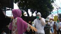 Petugas KPPS di Kabupaten Bandung kenakan Baju Hazmat sambut calon pemilih di TPS. (Liputan6.com/Dikdik Ripaldi)