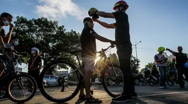 Pengendara sepeda mendapat helm gratis di Manila, Filipina (9/7/2020). Lembaga swadaya masyarakat membagikan helm dan selempang reflektif gratis saat warga beralih menggunakan sepeda sebagai moda transportasi utama selama pandemi COVID-19. (Xinhua/Rouelle Umali)