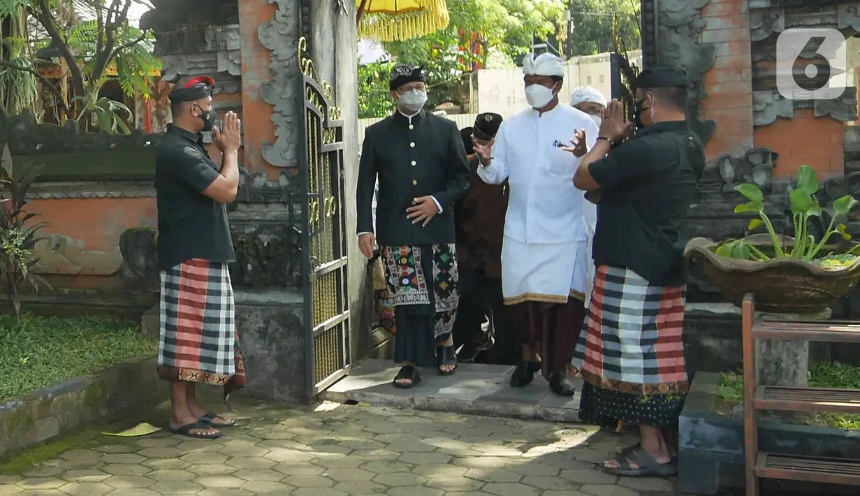 Gubernur DKI Jakarta, Anies Baswedan (baju hitam) berkeliling Pura Aditya Jaya saat menghadiri Upacara Tawur Agung Kesanga di Pulo Gadung, Rabu (2/3/2022). Anies yang mengenakan pakaian adat Bali dengan udeng hitam itu datang untuk menghormati umat Hindu di Jakarta. (Liputan6.com/Herman Zakharia)